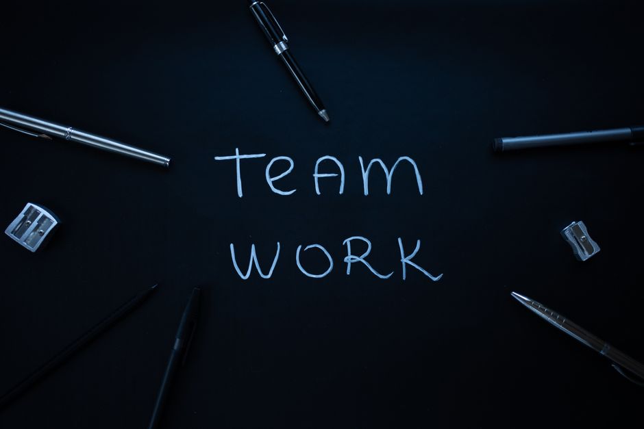 Elementos de trabajo en equipo dispuestos sobre fondo oscuro